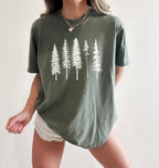Person wearing sage  t-shirt with white pine tree forest graphic, minimalist nature design for hiking and outdoor lovers on a white background