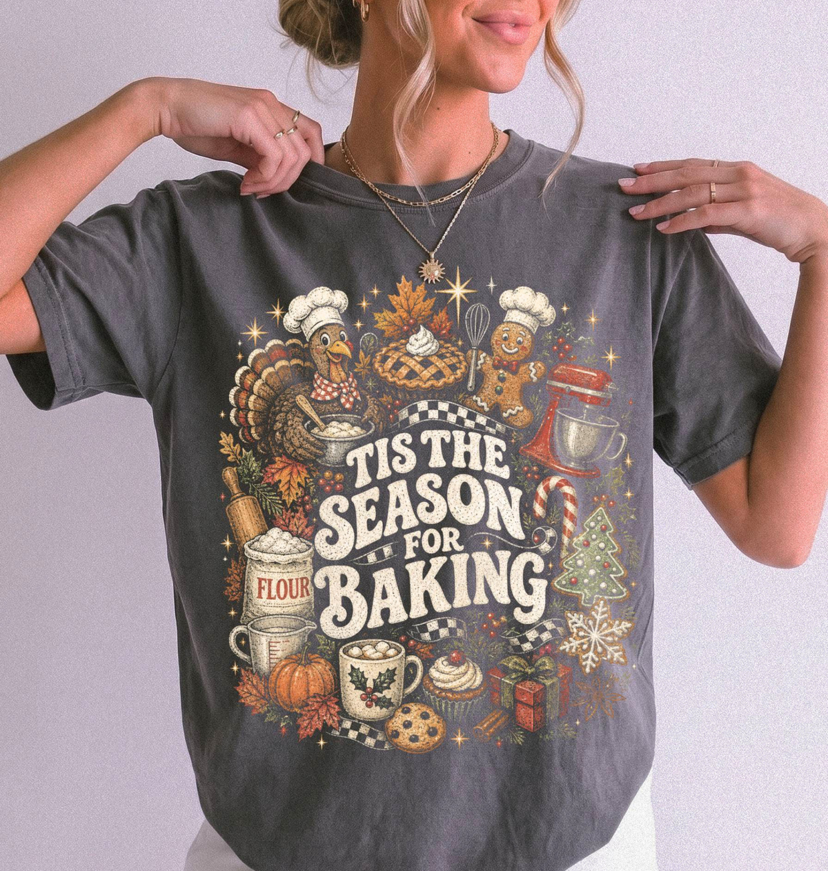 woman standing wearing a grey tshirt that says "tis the season for baking" surrounded in baking and fall icons