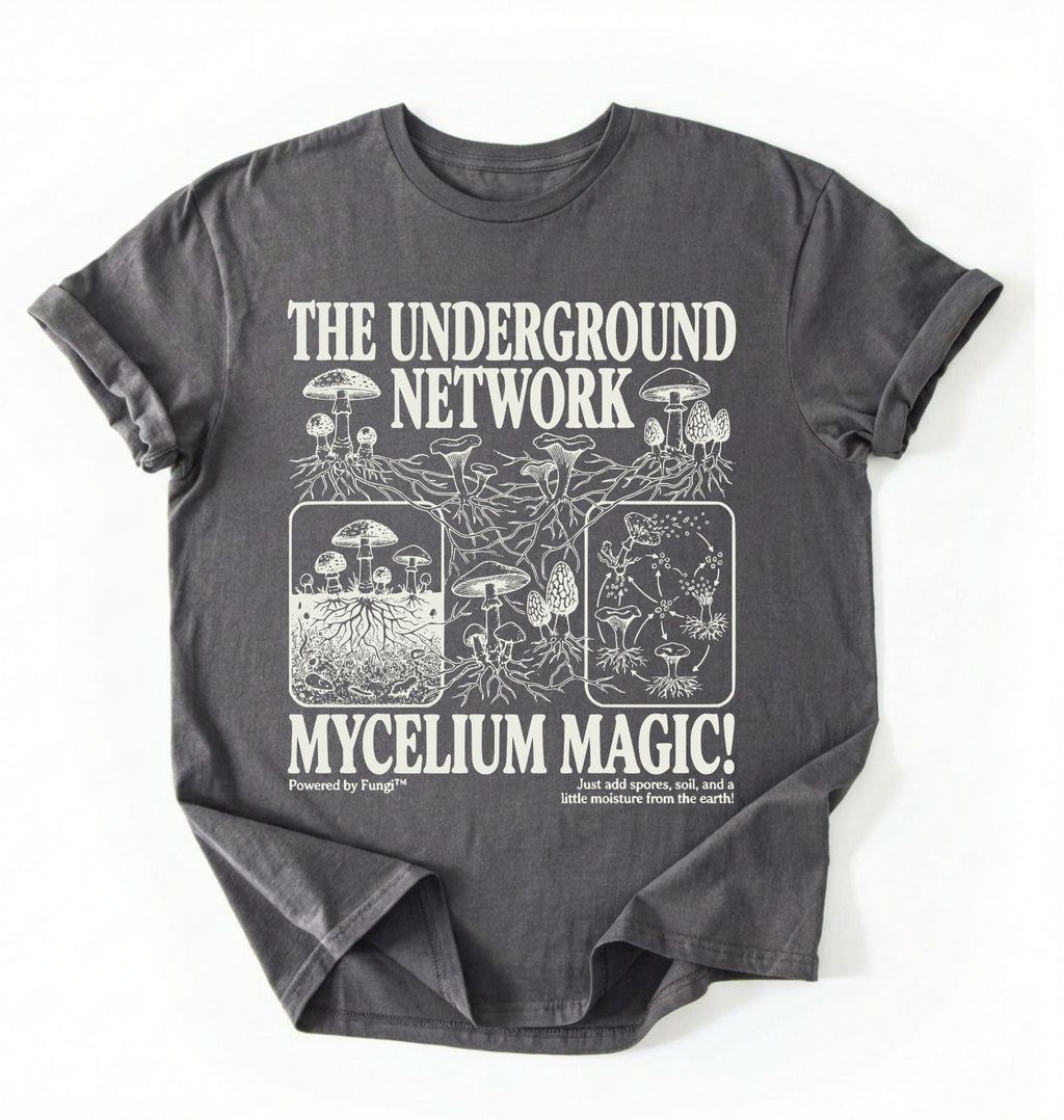 Flat lay of a Charcoal t-shirt featuring Mycelium network mushroom and root network illustrations with text reading “The Underground Network Mycelium Magic” with forest fungi design perfect gift for mushroom lovers nature fans and cottagecore style on a white background 
