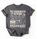Flat lay of a Charcoal t-shirt featuring Mycelium network mushroom and root network illustrations with text reading “The Underground Network Mycelium Magic” with forest fungi design perfect gift for mushroom lovers nature fans and cottagecore style on a white background 