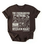 Flat lay of a brown chocolate t-shirt featuring Mycelium network mushroom and root network illustrations with text reading “The Underground Network Mycelium Magic” with forest fungi design perfect gift for mushroom lovers nature fans and cottagecore style on a white background 