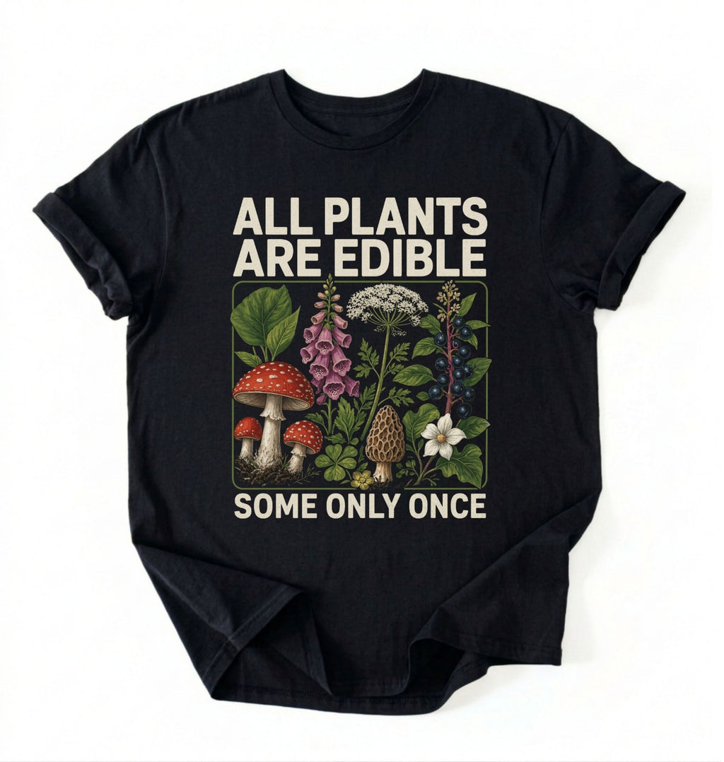 Flat lay of a black all plants are edible shirt black funny gardening t shirt plant lover gift botanical humor design on a white background 