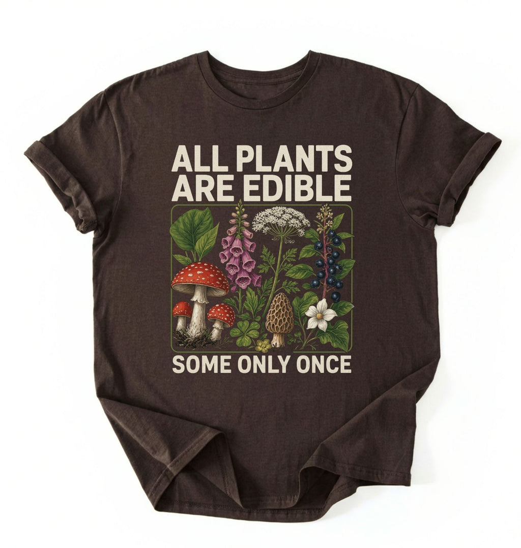 Flat lay of a dark chocolate all plants are edible shirt black funny gardening t shirt plant lover gift botanical humor design on a white background 