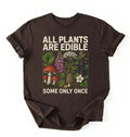 Flat lay of a dark chocolate all plants are edible shirt black funny gardening t shirt plant lover gift botanical humor design on a white background 
