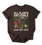 Flat lay of a dark chocolate all plants are edible shirt black funny gardening t shirt plant lover gift botanical humor design on a white background 