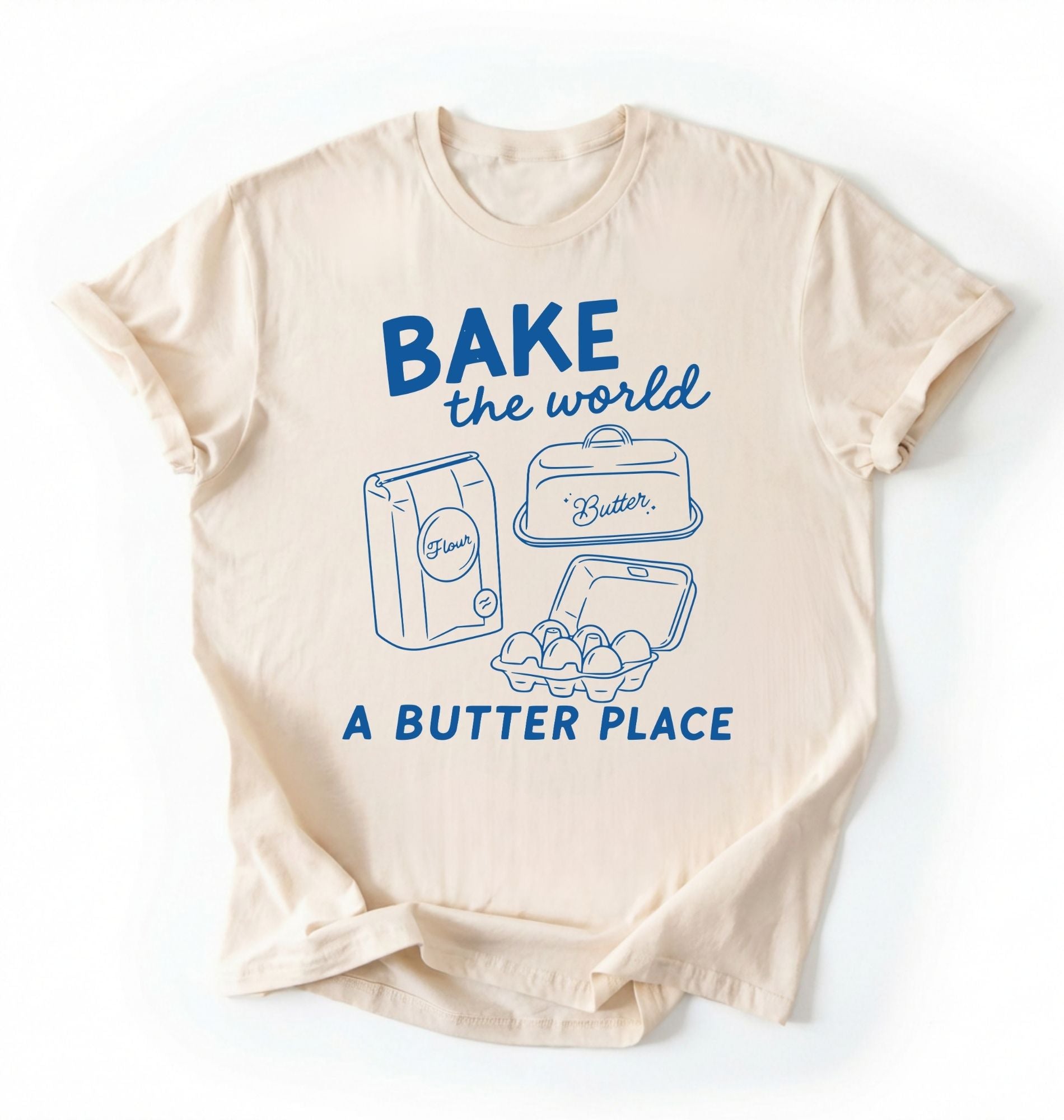 Flat lay of a Funny baking pun shirt with flour butter and eggs illustration on cream tee on a white background 