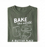 Flat lay of a Funny baking pun shirt with flour butter and eggs illustration on green tee on a white background 