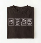 Flat lay of a brown Baking Addict Sourdough Mama graphic shirt with vintage baking stamp design for bread bakers on a white background 