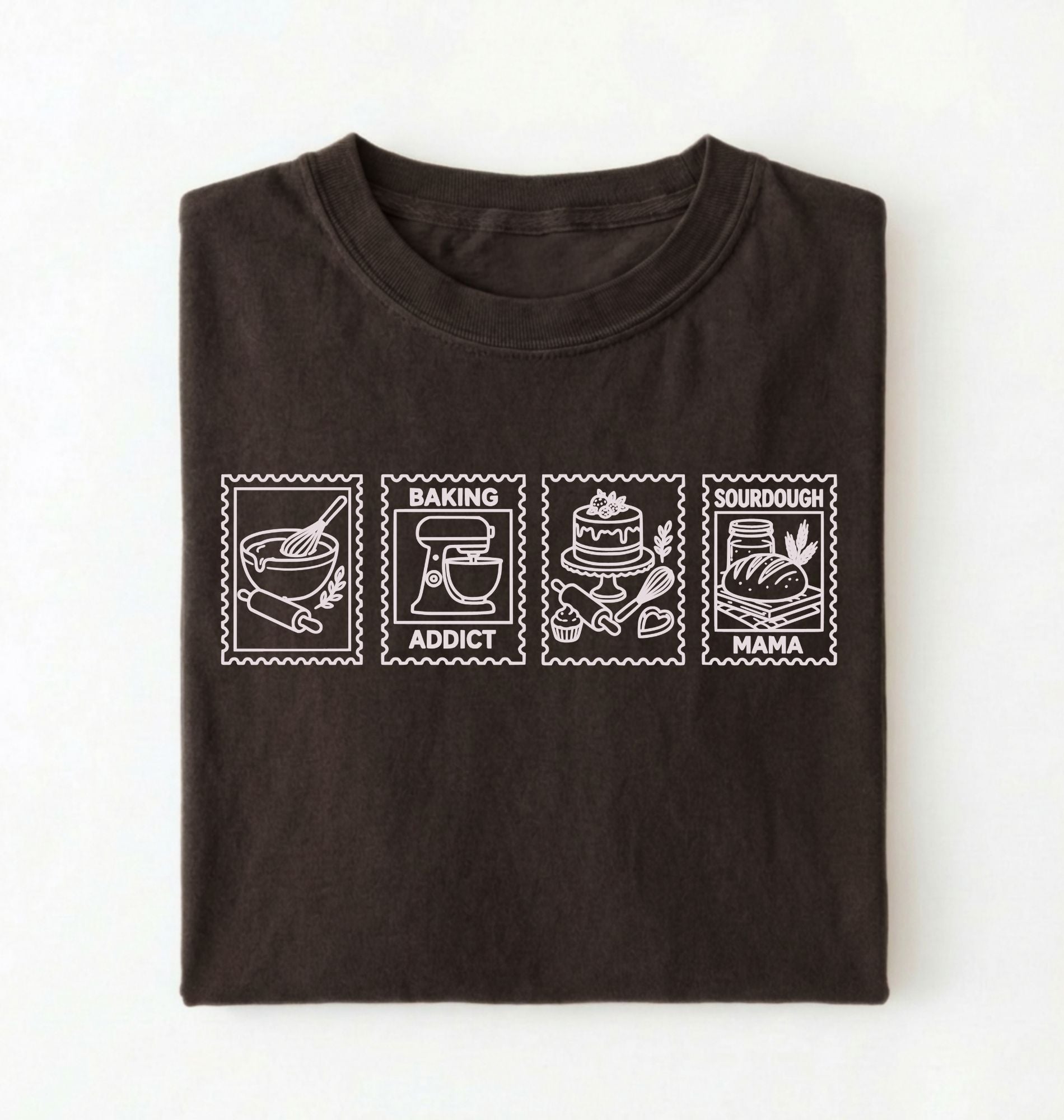 Flat lay of a brown Baking Addict Sourdough Mama graphic shirt with vintage baking stamp design for bread bakers on a white background 
