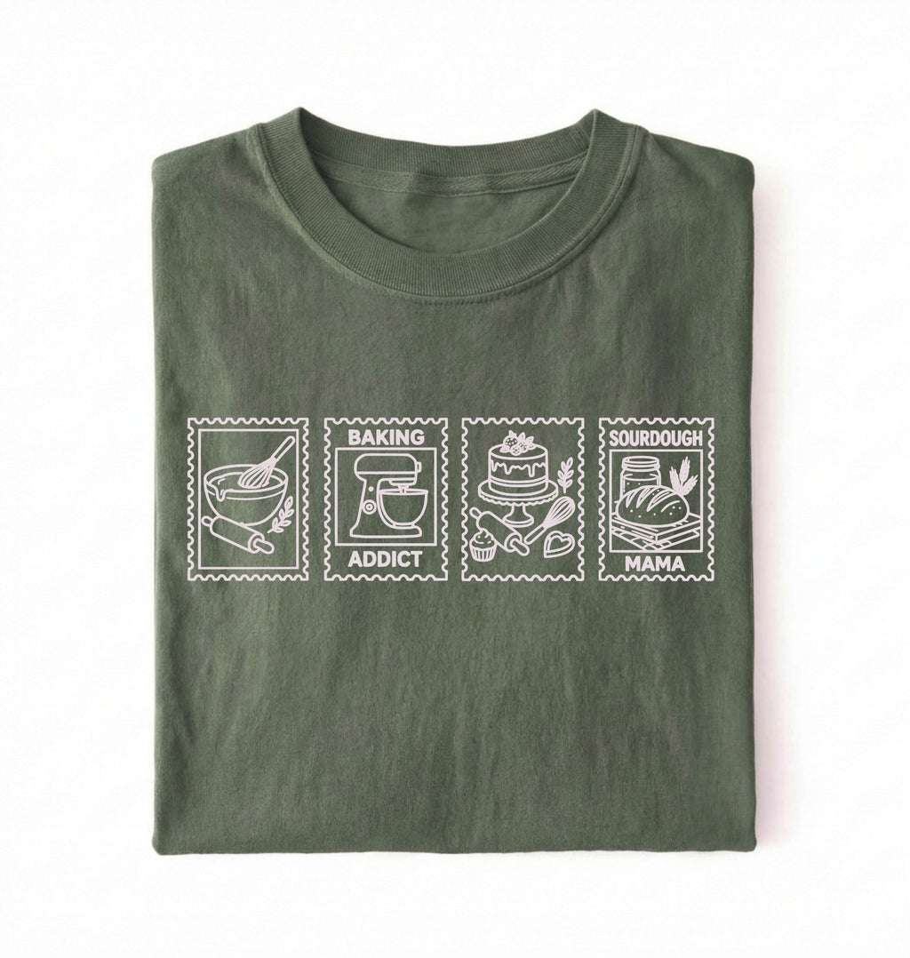 Flat lay of a green Baking Addict Sourdough Mama graphic shirt with vintage baking stamp design for bread bakers on a white background 