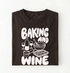 Flat lay of a brown Baking and Wine graphic shirt for home bakers featuring baking tools and wine themed design on a white background