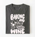 Flat lay of a gray Baking and Wine graphic shirt for home bakers featuring baking tools and wine themed design on a white background
