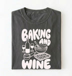 Flat lay of a gray Baking and Wine graphic shirt for home bakers featuring baking tools and wine themed design on a white background