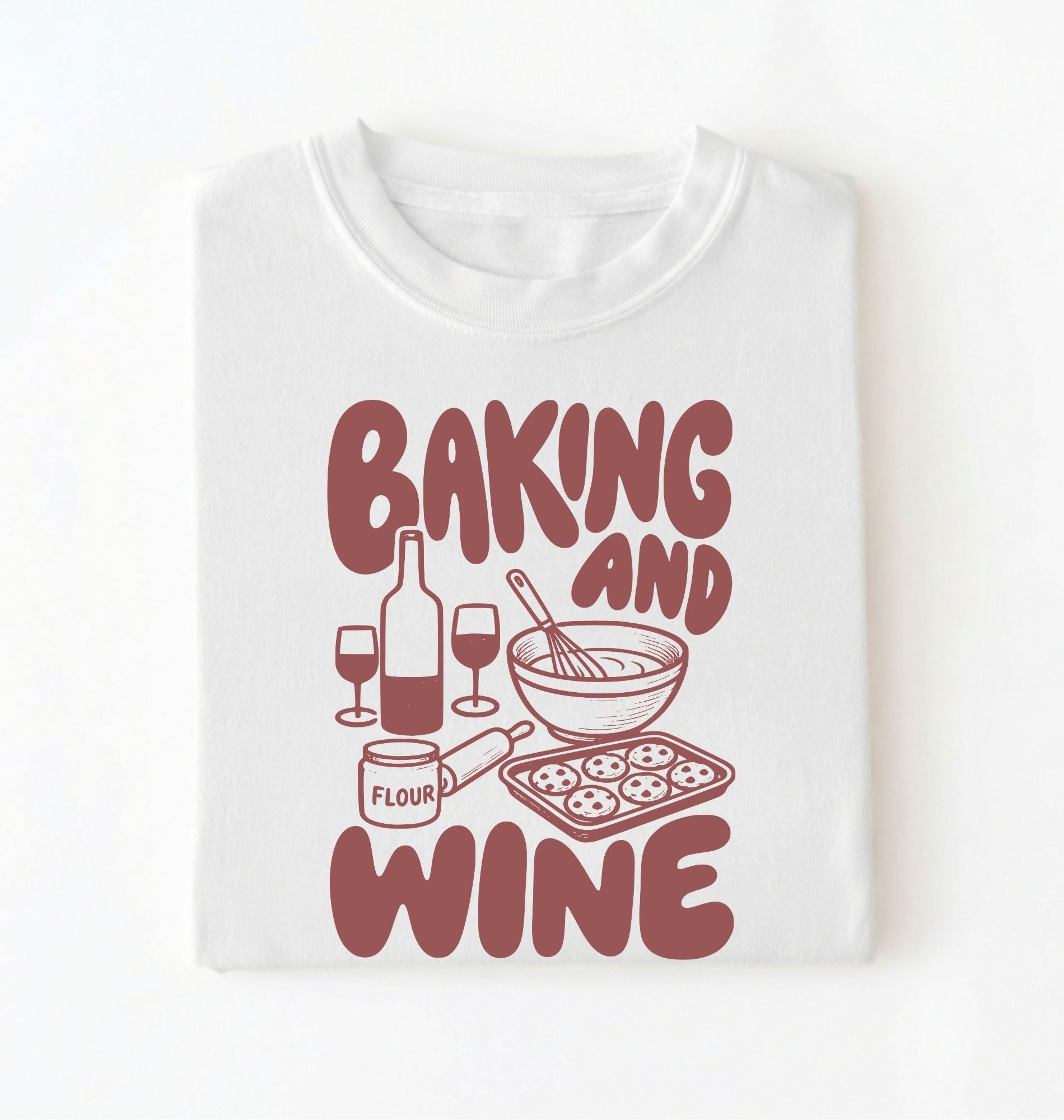 Flat lay of a white Baking and Wine graphic shirt for home bakers featuring baking tools and wine themed design on a white background