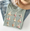T-shirt with cartoon duck illustrations on a denim surface with a hat and jeans.