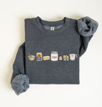 Flat lay of a dark heather baking ingredients sweatshirt with flour butter sugar eggs vanilla and baking essentials design on a white background