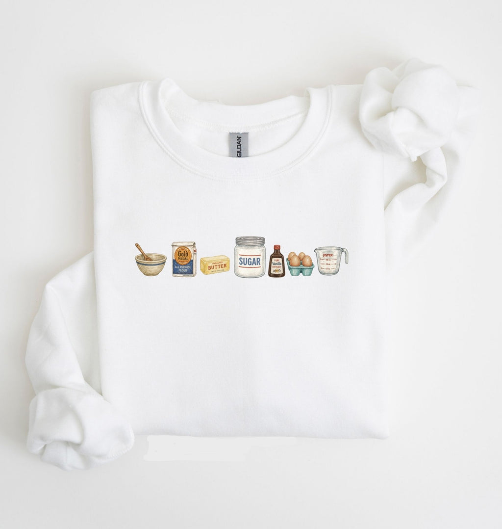 Flat lay of a white baking ingredients sweatshirt with flour butter sugar eggs vanilla and baking essentials design on a white background