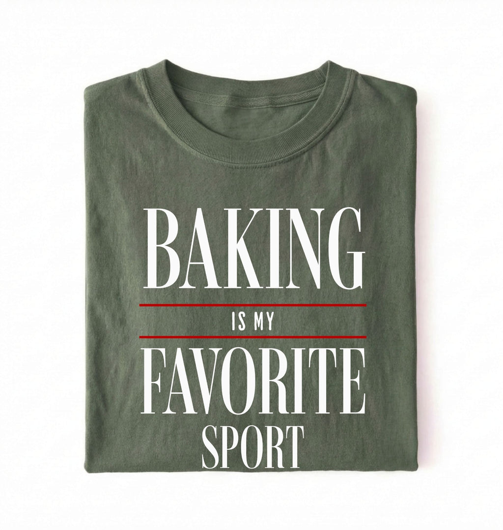 Flat lay of a green Baking Is My Favorite Sport graphic shirt for home bakers and baking enthusiasts on a white background 