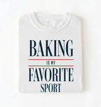 Flat lay of a white Baking Is My Favorite Sport graphic shirt for home bakers and baking enthusiasts on a white background 