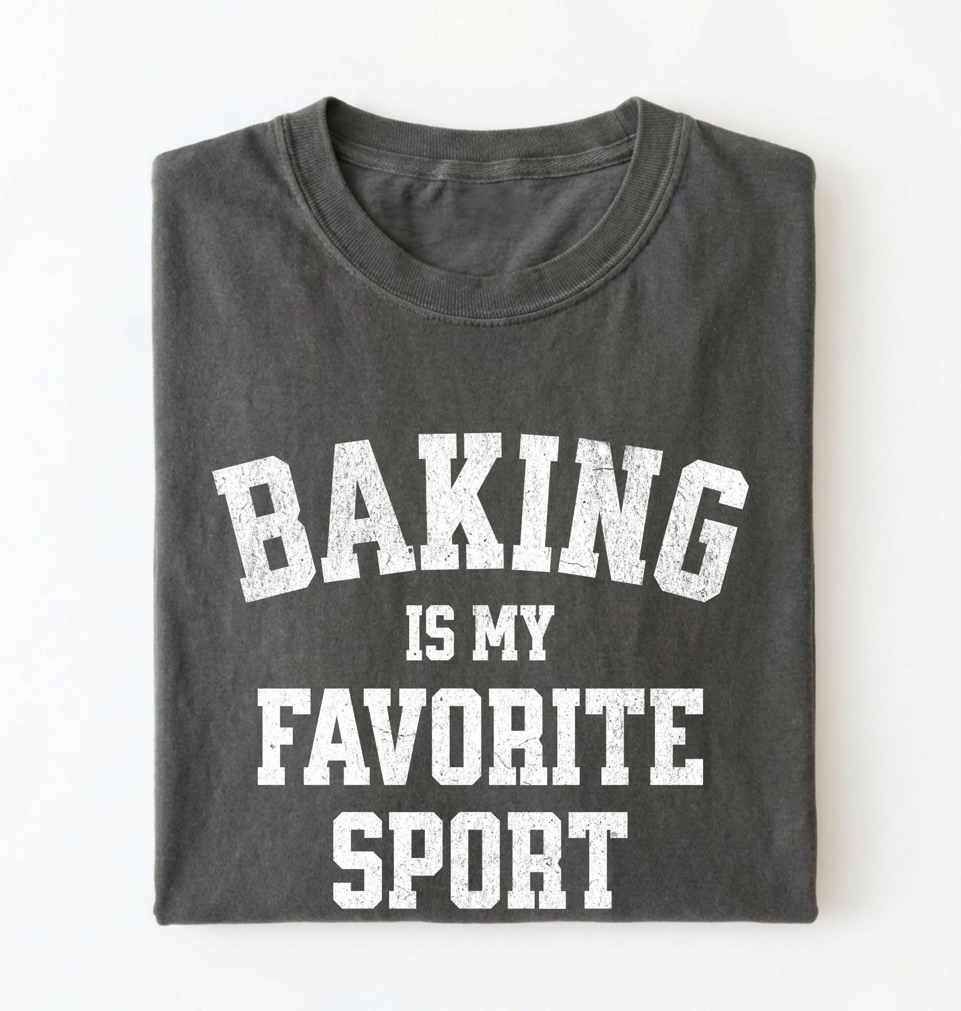 Flat lay of a pepper Baking Is My Favorite Sport graphic shirt on navy blue t-shirt for home bakers on a white background 