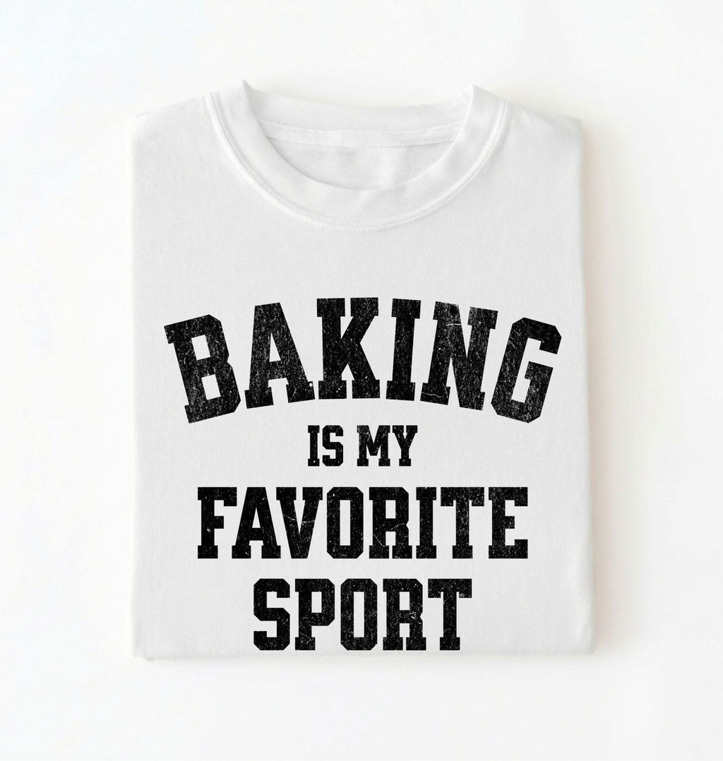 Flat lay of a white Baking Is My Favorite Sport graphic shirt on navy blue t-shirt for home bakers on a white background 