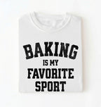 Flat lay of a white Baking Is My Favorite Sport graphic shirt on navy blue t-shirt for home bakers on a white background 