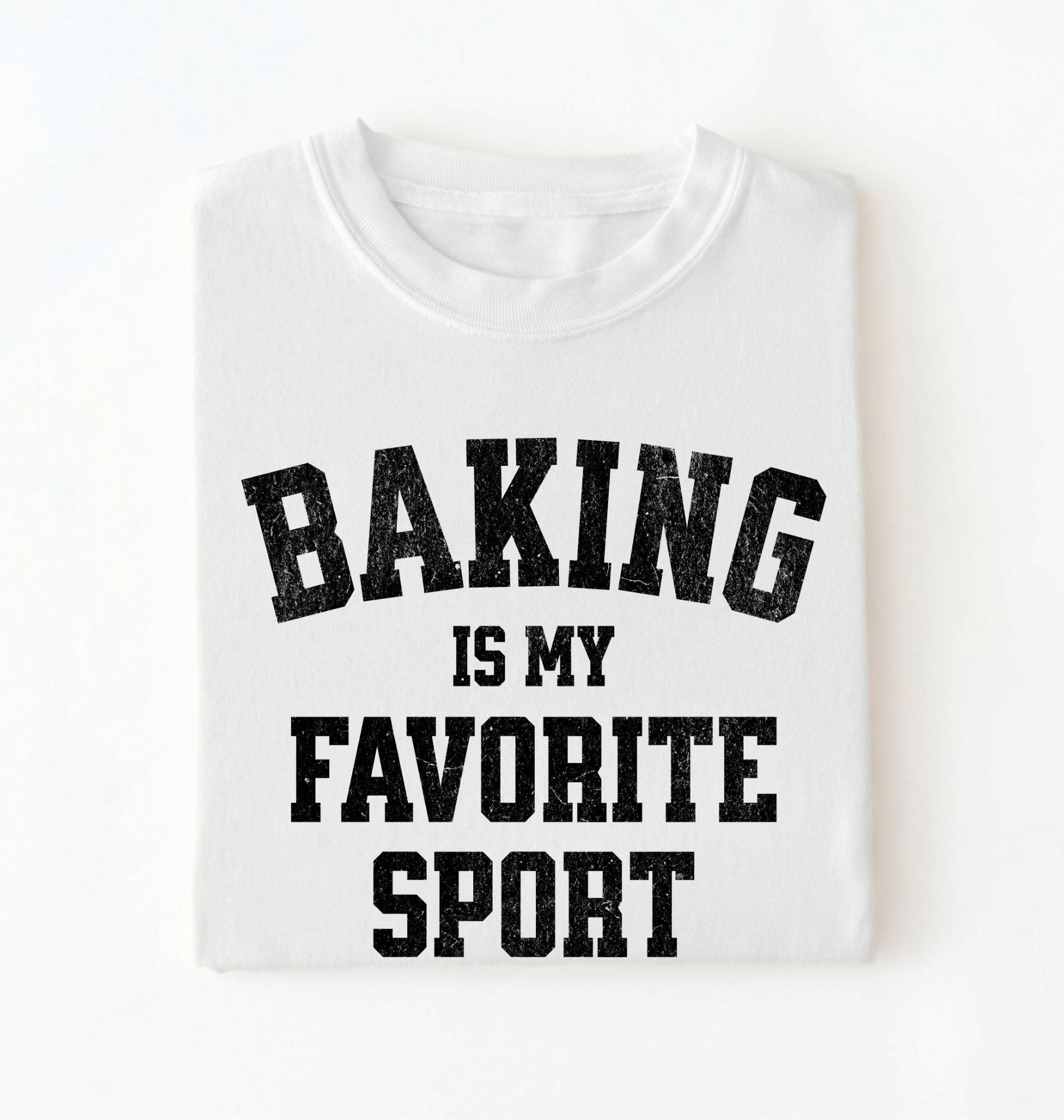 Flat lay of a white Baking Is My Favorite Sport graphic shirt on navy blue t-shirt for home bakers on a white background 