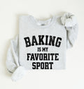 Flat lay of an ash Baking Is My Favorite Sport graphic sweatshirt on navy blue crewneck for home bakers on white background