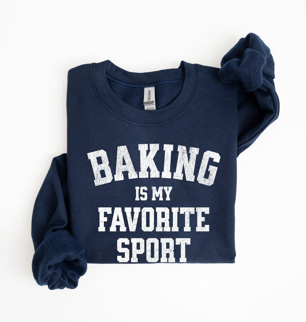 Flat lay of a navy Baking Is My Favorite Sport graphic sweatshirt on navy blue crewneck for home bakers on white background