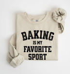 Flat lay of a sand Baking Is My Favorite Sport graphic sweatshirt on navy blue crewneck for home bakers on white background