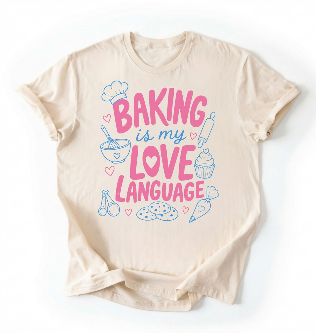 Flat lay of a Baking Is My Love Language shirt with baking tools and dessert graphics on cream t-shirt on a white background