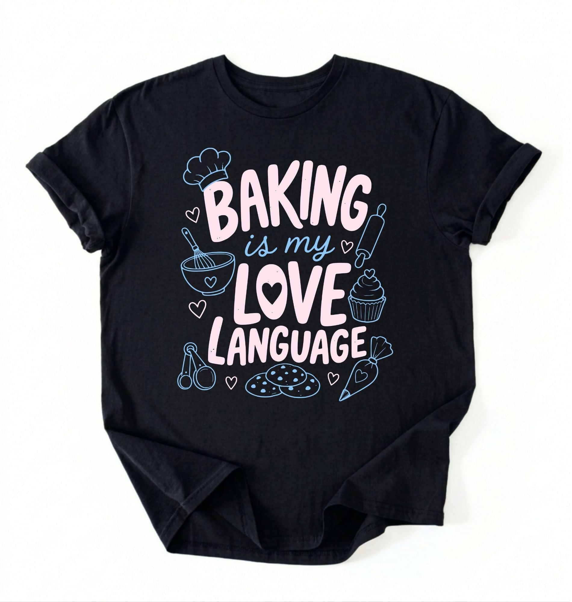 Flat lay of a Baking Is My Love Language shirt with baking tools and dessert graphics on black t-shirt on a white background