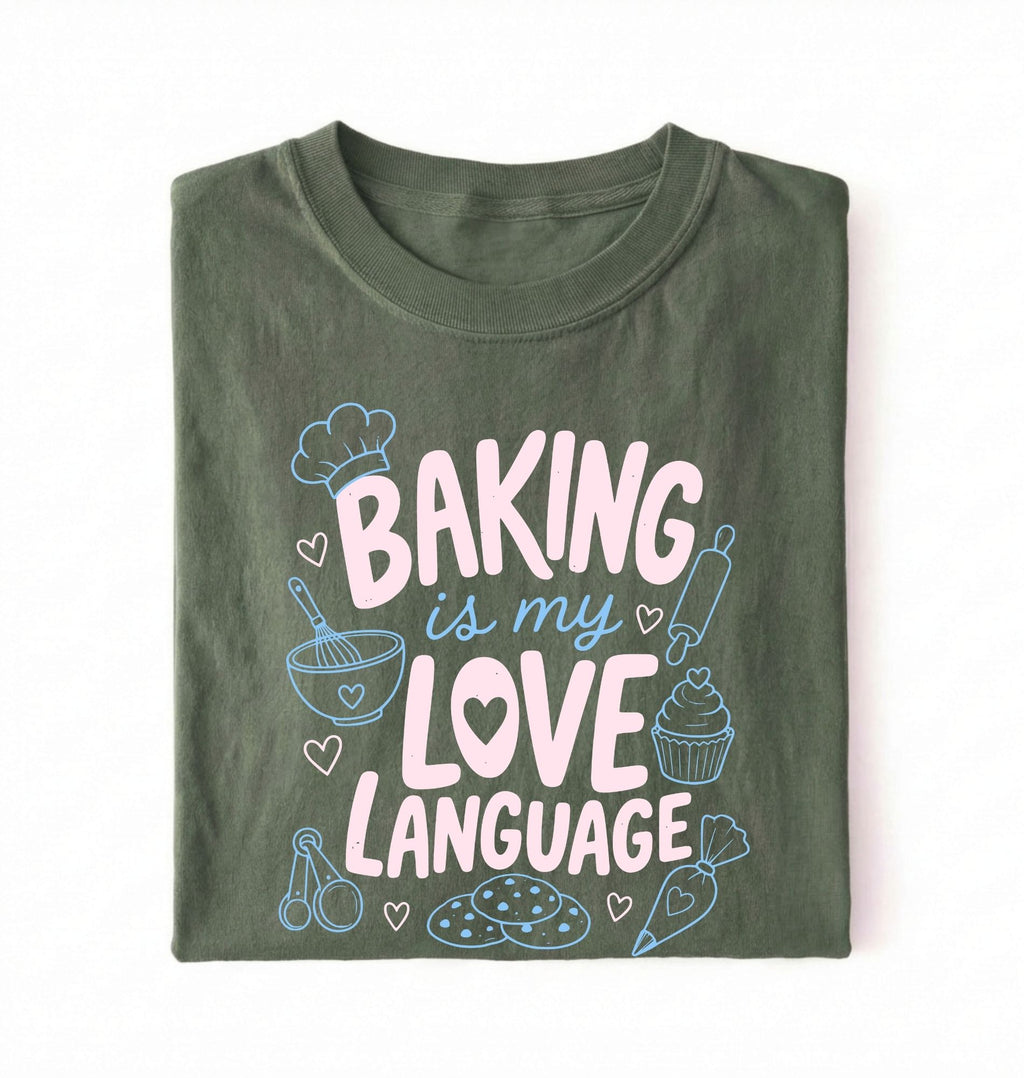 Flat lay of a Baking Is My Love Language shirt with baking tools and dessert graphics on green t-shirt on a white background
