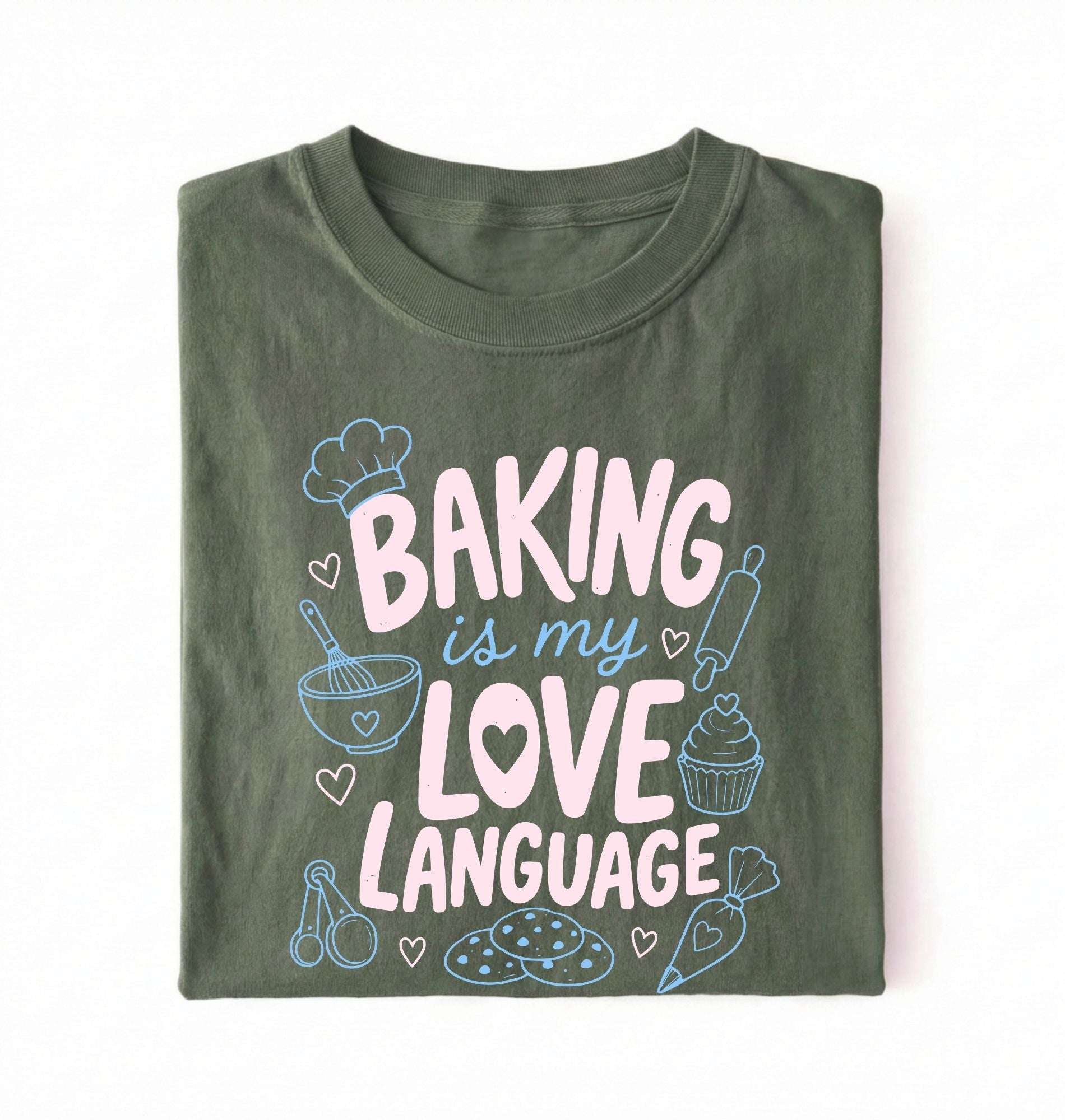 Flat lay of a Baking Is My Love Language shirt with baking tools and dessert graphics on green t-shirt on a white background