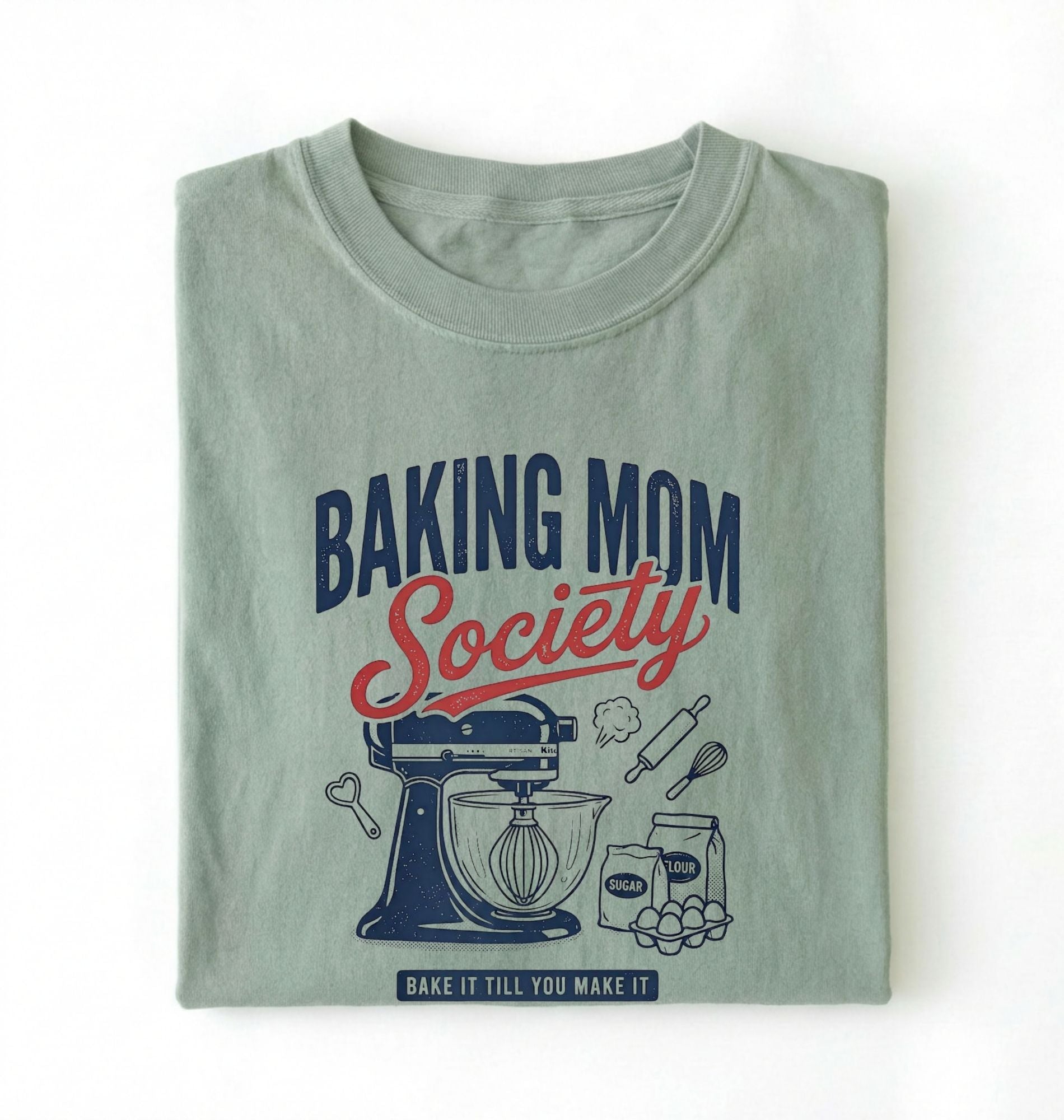 Flat lay of a bay baking mom society shirt with stand mixer and baking ingredients baking mom gift on a white background 