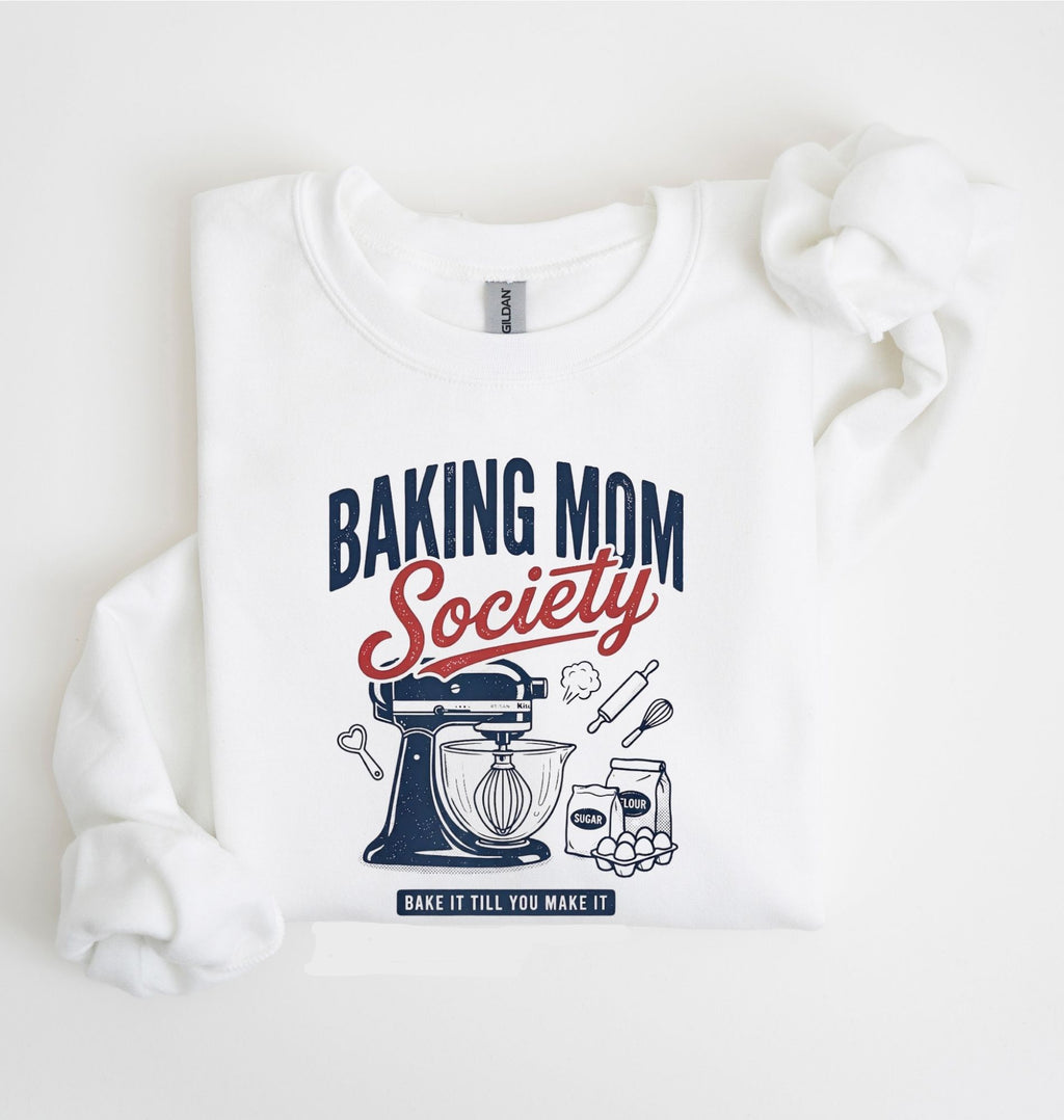 Flat lay of a white Baking Mom Society graphic sweatshirt featuring a vintage mixer and baking tools for home bakers on a white background 