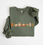 An olive green long-sleeve crewneck sweatshirt with a graphic of baking ingredients and tools printed on the chest, styled with rolled cuffs and a matching fabric scrunchie on a white background.