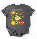 Flat lay white t shirt with the text White t-shirt with citrus fruit graphic and text 'Citrus Got Real' on a white background