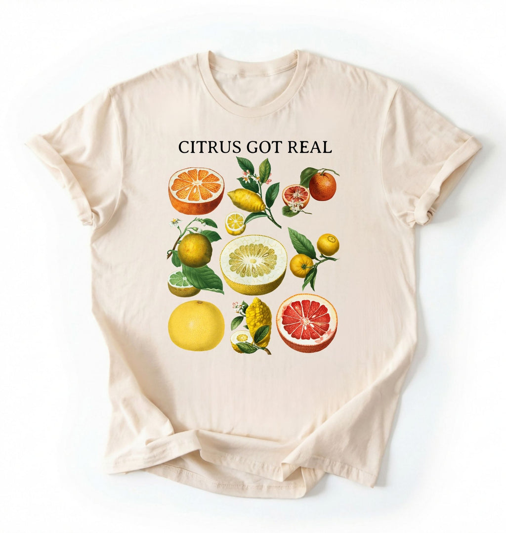 Flat lay ivory t shirt with the text White t-shirt with citrus fruit graphic and text 'Citrus Got Real' on a white background