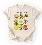 Flat lay ivory t shirt with the text White t-shirt with citrus fruit graphic and text 'Citrus Got Real' on a white background