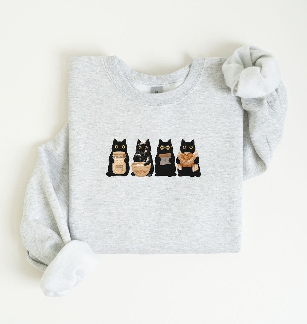 Flat lay of an ash Cute black cat baker sweatshirt featuring baking cats with bread and mixing bowl crewneck on a white background 
