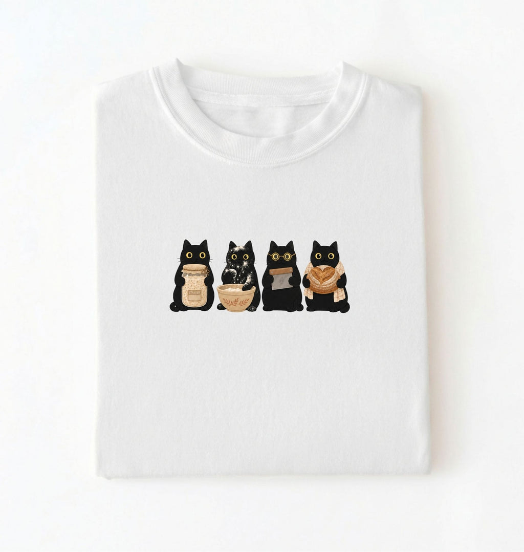 Flat lay of a Cute black cat baker shirt featuring baking cats with bread and mixing bowl on white t-shirt on a white background 