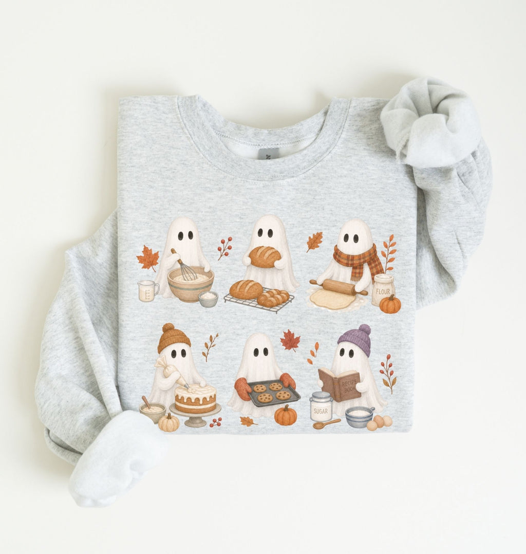A light heather gray sweatshirt laid flat on a white background, featuring a cute cartoon graphic of six ghosts dressed in autumn outfits with bread, pumpkins, leaves, and cozy accessories.