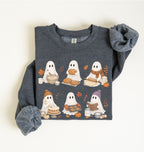 A dark heather gray long-sleeve sweatshirt with a graphic of six cute cartoon ghosts sharing a fall picnic, featuring bread, pumpkin, and autumn leaves, shown on a clean off-white background.