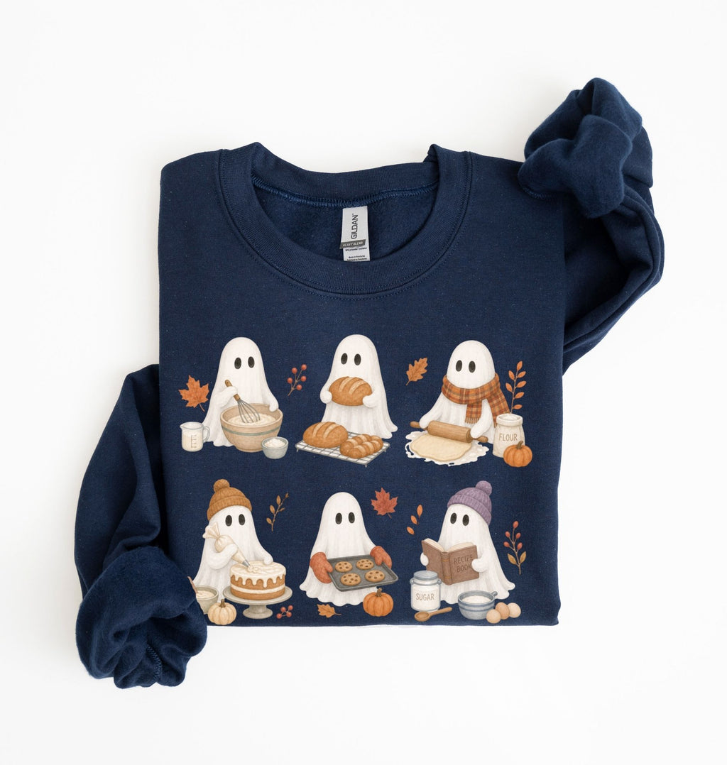 A navy blue crewneck sweatshirt with a long-sleeve cuff folded over, featuring a graphic of cute cartoon ghosts eating autumn treats like bread, pumpkin pie, and candy corn. The sweatshirt is displayed flat on a clean white background.