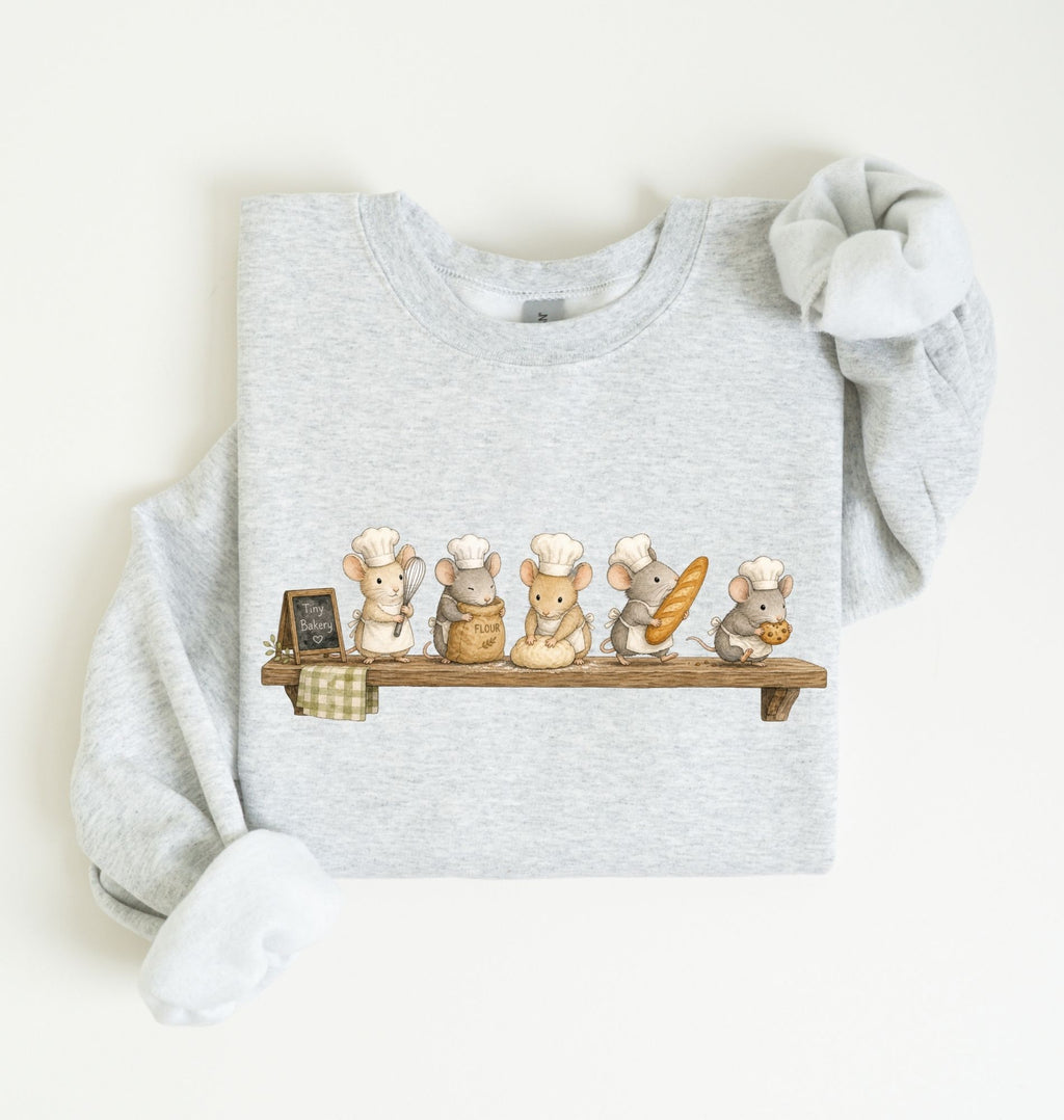 A light heather gray long-sleeve sweatshirt with a graphic of five cute cartoon mice dressed as chefs sitting on a wooden shelf, displayed flat on a warm off-white background.