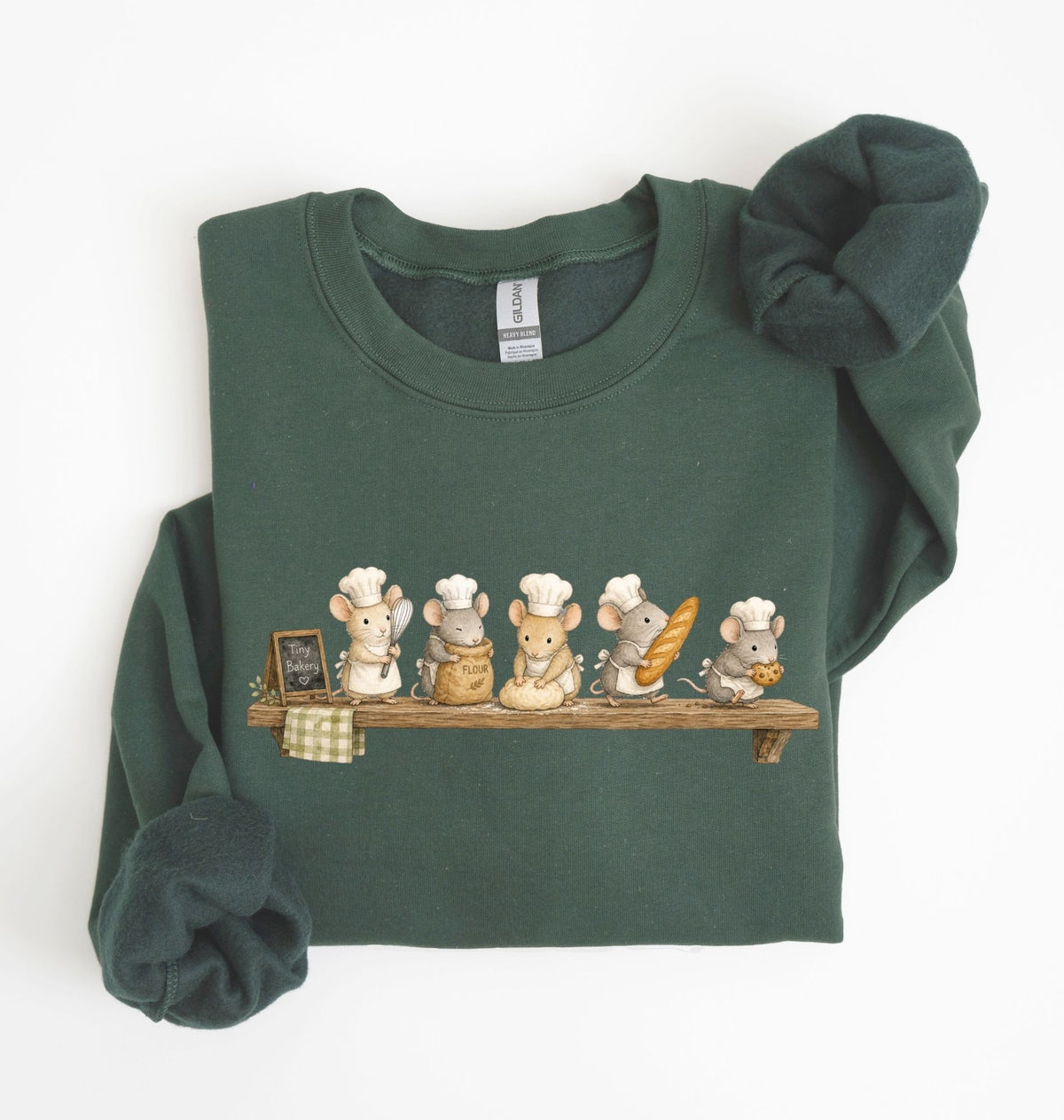 A dark green long-sleeve sweatshirt with a graphic of six cartoon mice dressed as chefs sitting on a wooden shelf. The sweatshirt is neatly folded with the sleeves rolled up, set against a plain white background.