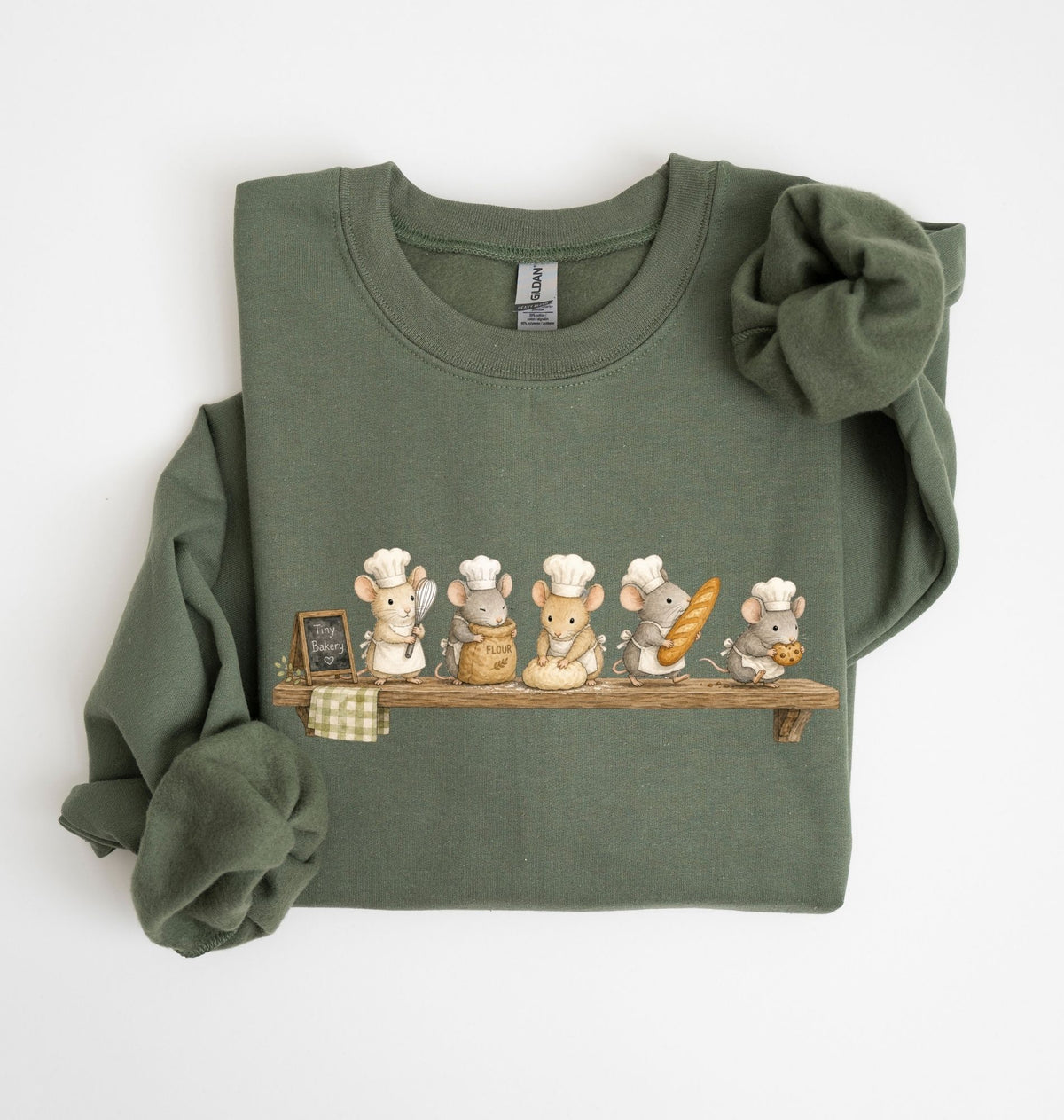 An olive green long-sleeve sweatshirt with a graphic of five cartoon mice wearing chef hats and holding baking utensils on a wooden shelf, displayed flat on a white background.