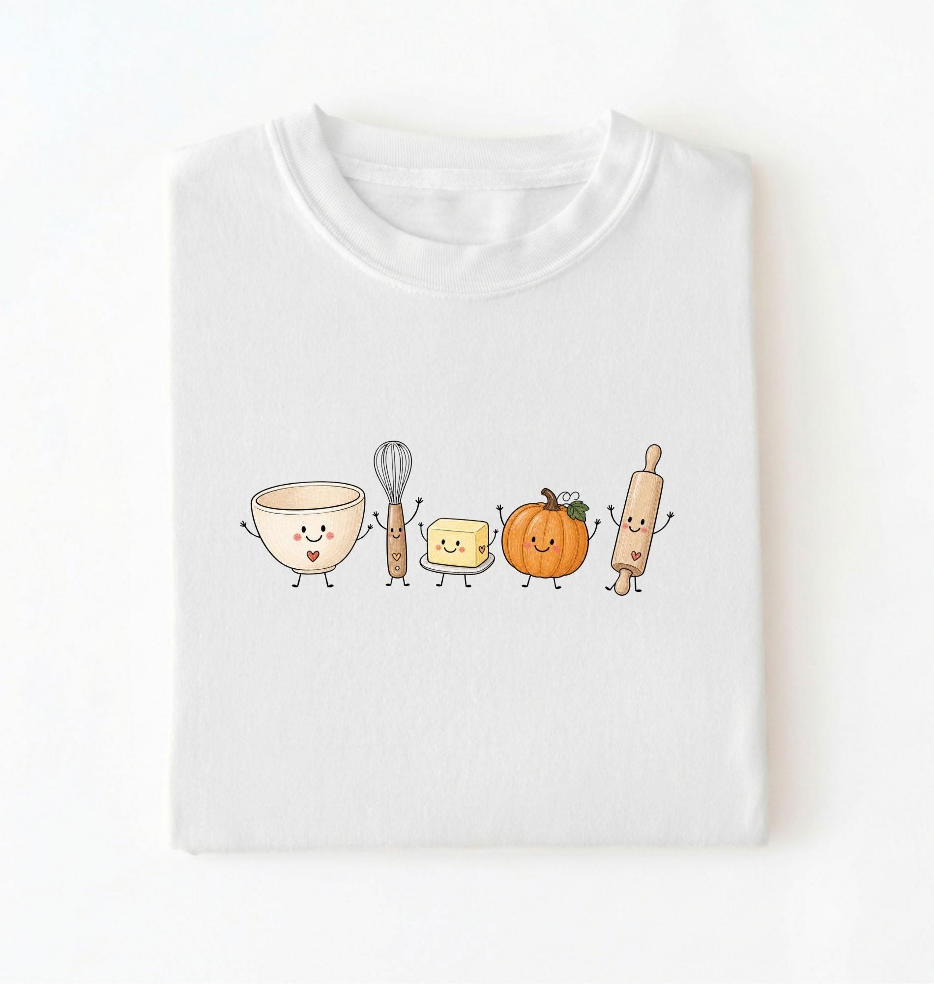 White fall baking shirt featuring cute smiling illustrations of a mixing bowl, whisk, butter, pumpkin and rolling pin