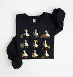 A black crewneck sweatshirt featuring a graphic print of nine cartoon ducks gardening in various poses, shown folded on a white background.